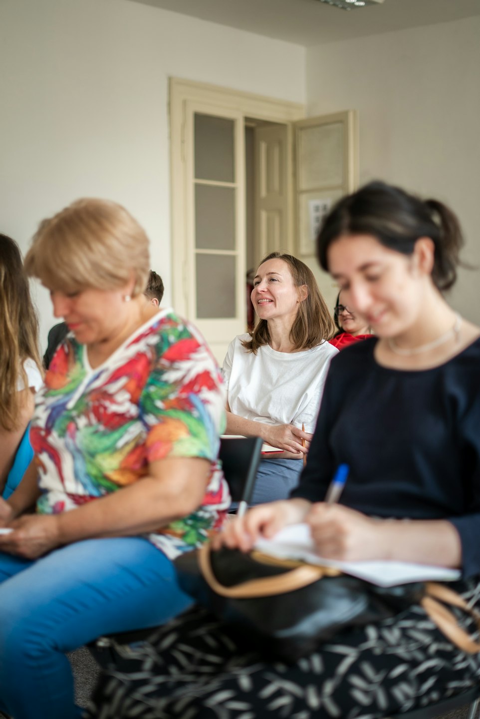 Attendees engaged in a workshop, listening intently to a speaker.